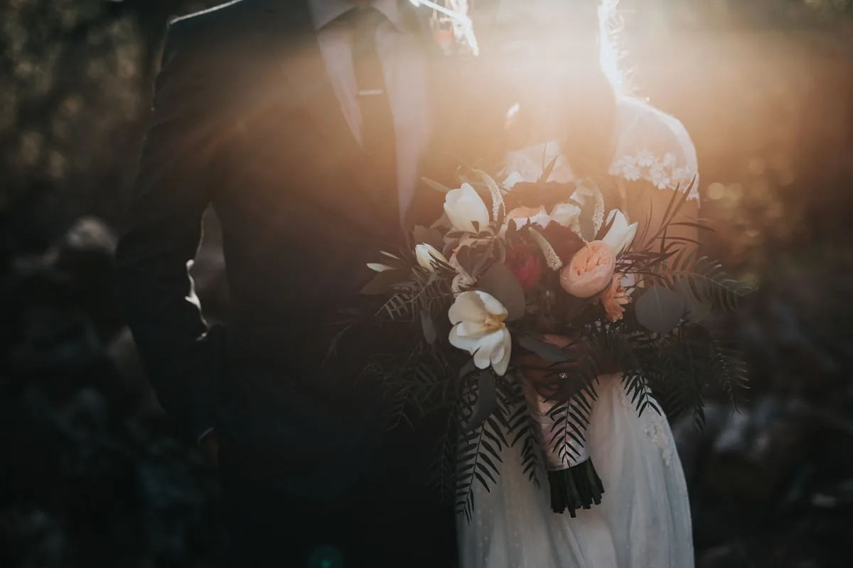 Newlywed couple standing together with a wedding bouquet