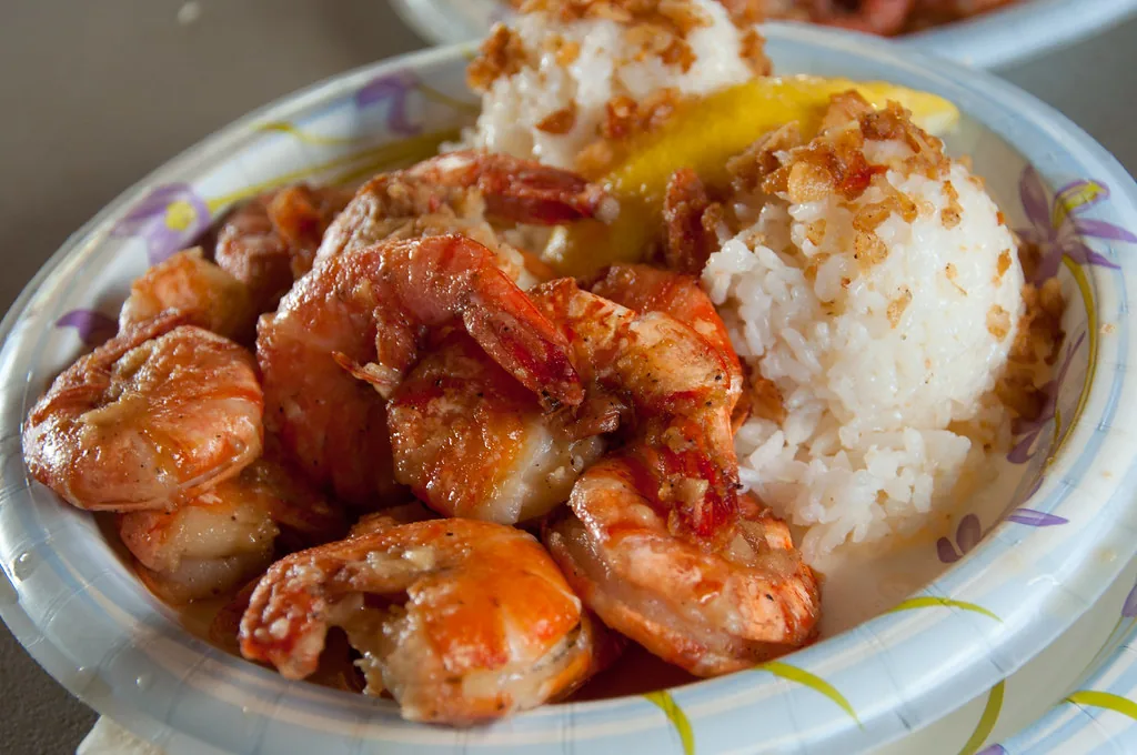 Cooked seasoned shrimp served with rice and lemon